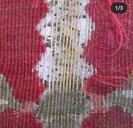 Gedetailleerde foto van een ernstig beschadigde Turkse Kilim, in afwachting van professionele tapijtreparatie en restauratie.